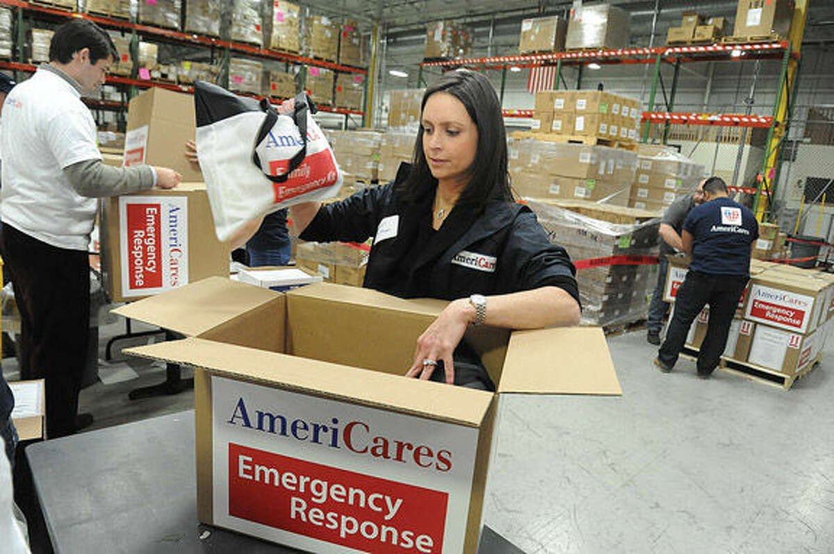 Megin Wolfman, a corporate officer at AmeriCares, helps pack emergency kits at the global relief organization’s Stamford headquarters Tuesday evening. 