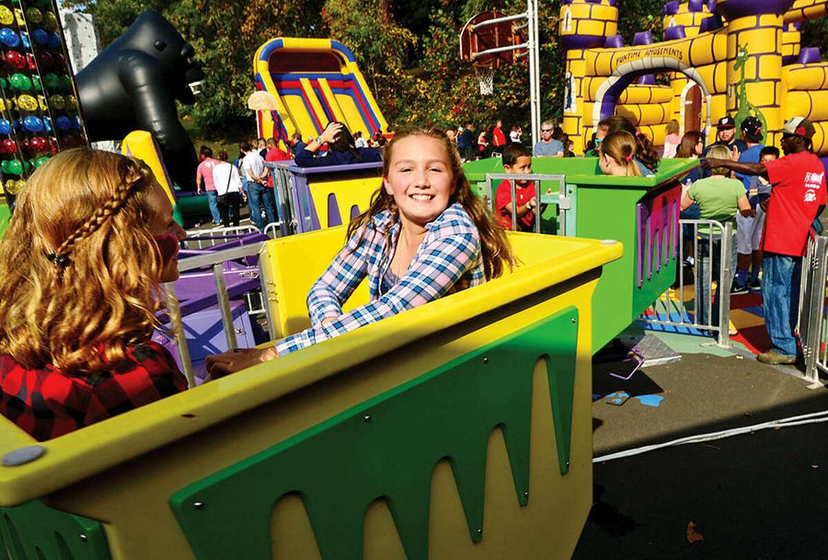 Hour photo / Erik Trautmann Brin Renwick and her friend Dylan Ackerman, both 11, ride on of the attractions at the Wolfpit Elementary School annual Pumpkin Festival Saturday.