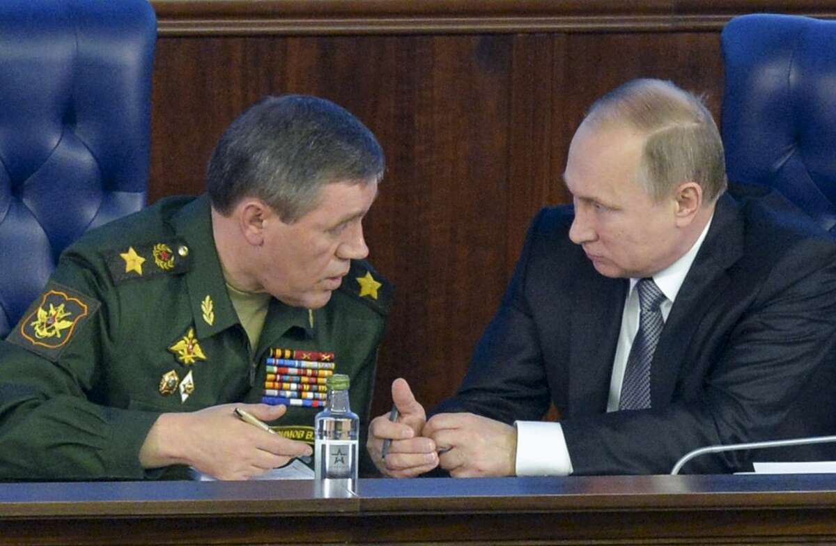 Russian President Vladimir Putin, right, speaks with Chief of the General Staff of the Russian Armed Forces Valery Gerasimov at a meeting with top military officials in the National Defense Control Center in Moscow, Russia, Friday, Dec. 11, 2015. President Vladimir Putin said that a Russian military action in Syria is aimed at protecting Russia from extremists based there. (Alexei Druzhinin/Sputnik, Kremlin Pool Photo via AP)