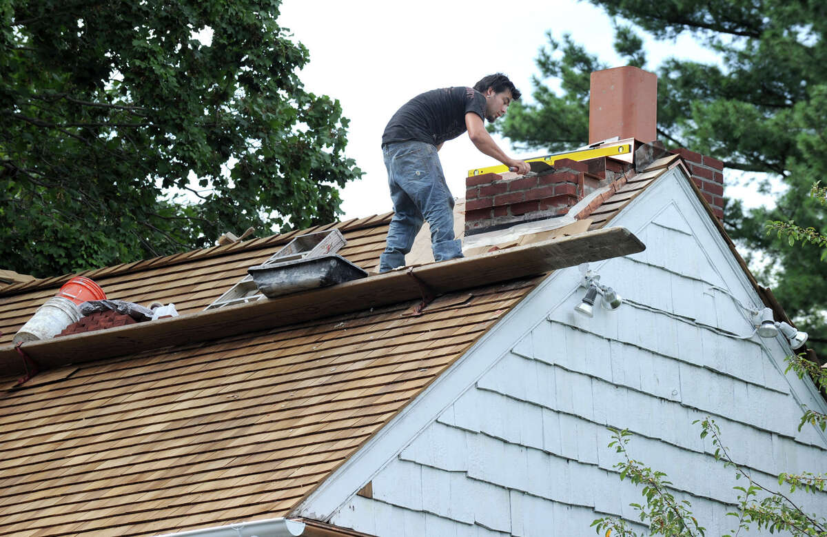 Johnny Arce, a subcontractor, completes work on a new chimney at the Richter House in Danbury Tuesday. Photo taken Tuesday, August 16, 2011.