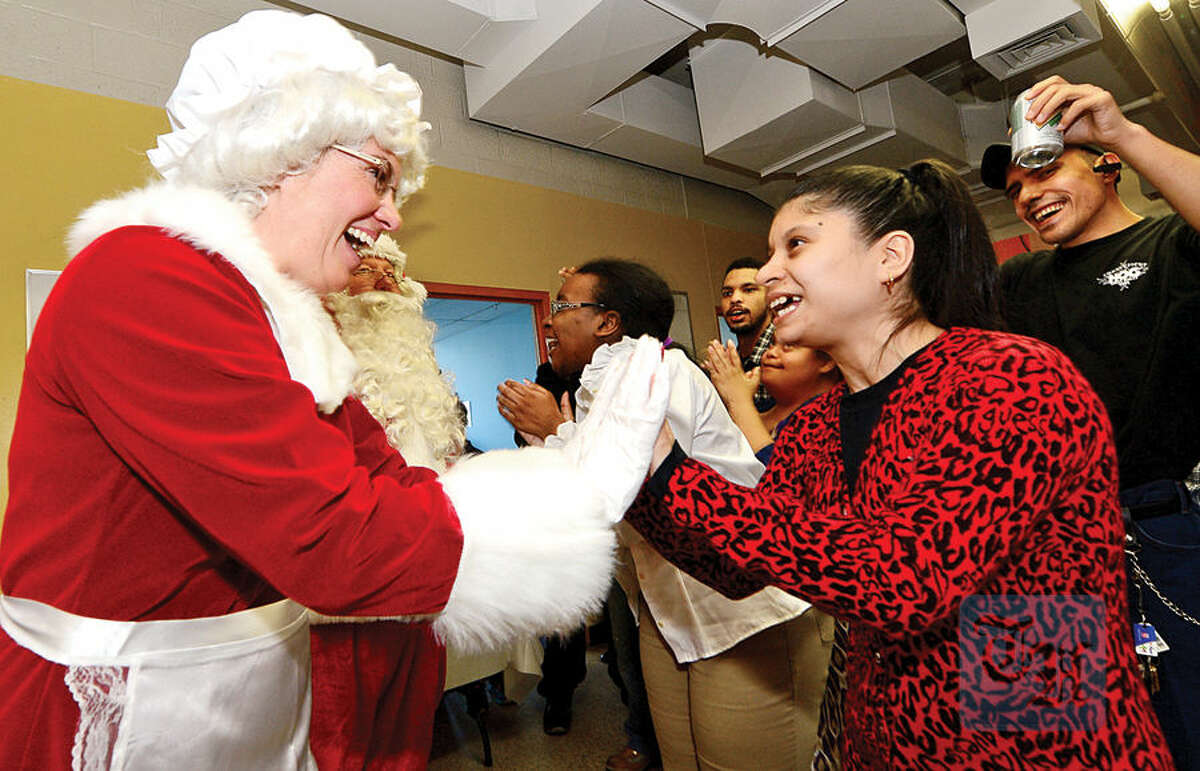 Mrs. Claus, aka Officer Heather Franc, greets Always Reaching for Independence (ARI) clients including Jessie E. as The Stamford Police Association co-hosts the 60th annual holiday party for developmentally disabled teens and adults at ARI of Connecticut, Inc.