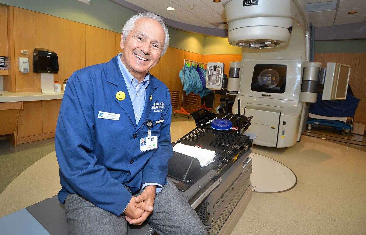 Hour Photo/Alex von Kleydorff Norwalk Hospitals President of the Volunteers and a volunteer himself with some 600 hours Corky Stewart in the Main Radiation Treatment room where he works with patients