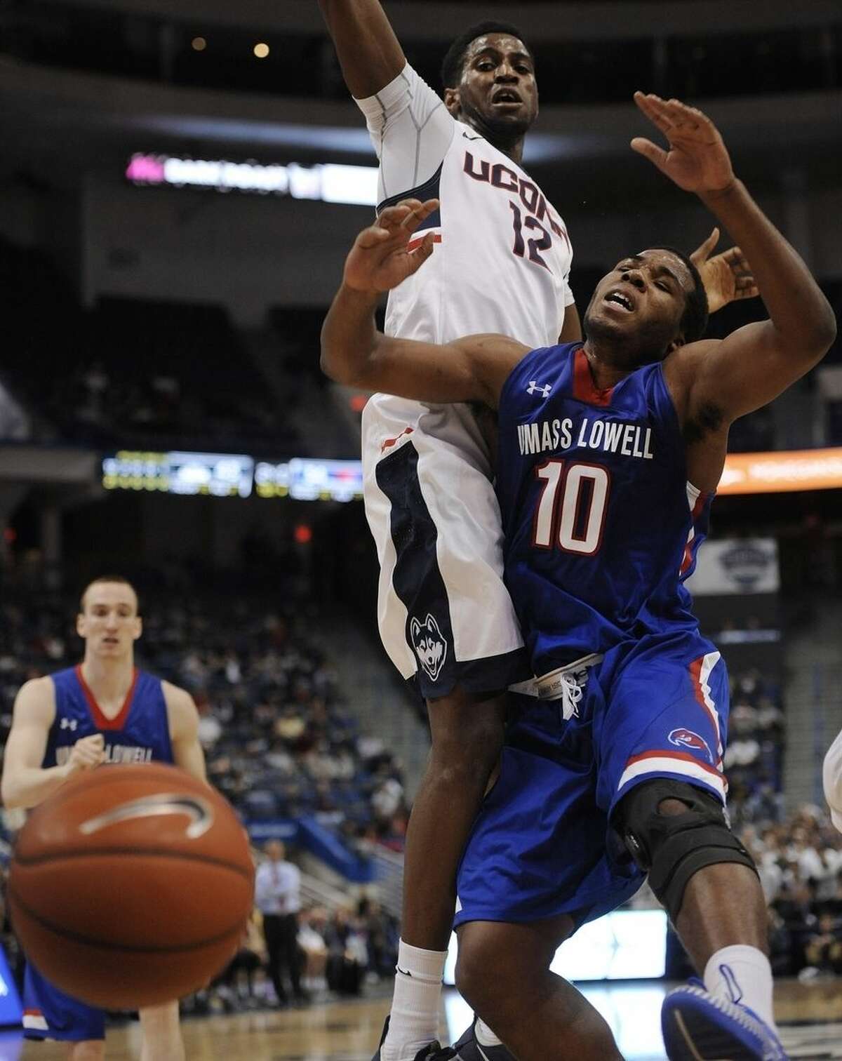 Connecticut's Kentan Facey, left, and UMass-Lowell’s Jahad Thomas, collide in the first half of an NCAA college basketball game, Sunday, Dec. 20, 2015, in Hartford, Conn. (AP Photo/Jessica Hill)