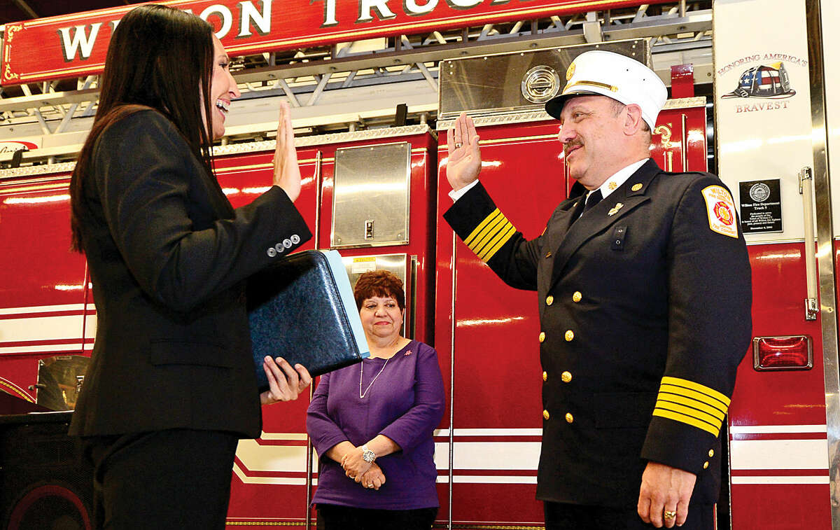 Wilton Fire Chief Ronald Kanterman is sworn in by Wilton Town Clerk Laurie Kaback, as Kanterma's wife, Kay, looks on during a ceremony at fire headquarters Friday.