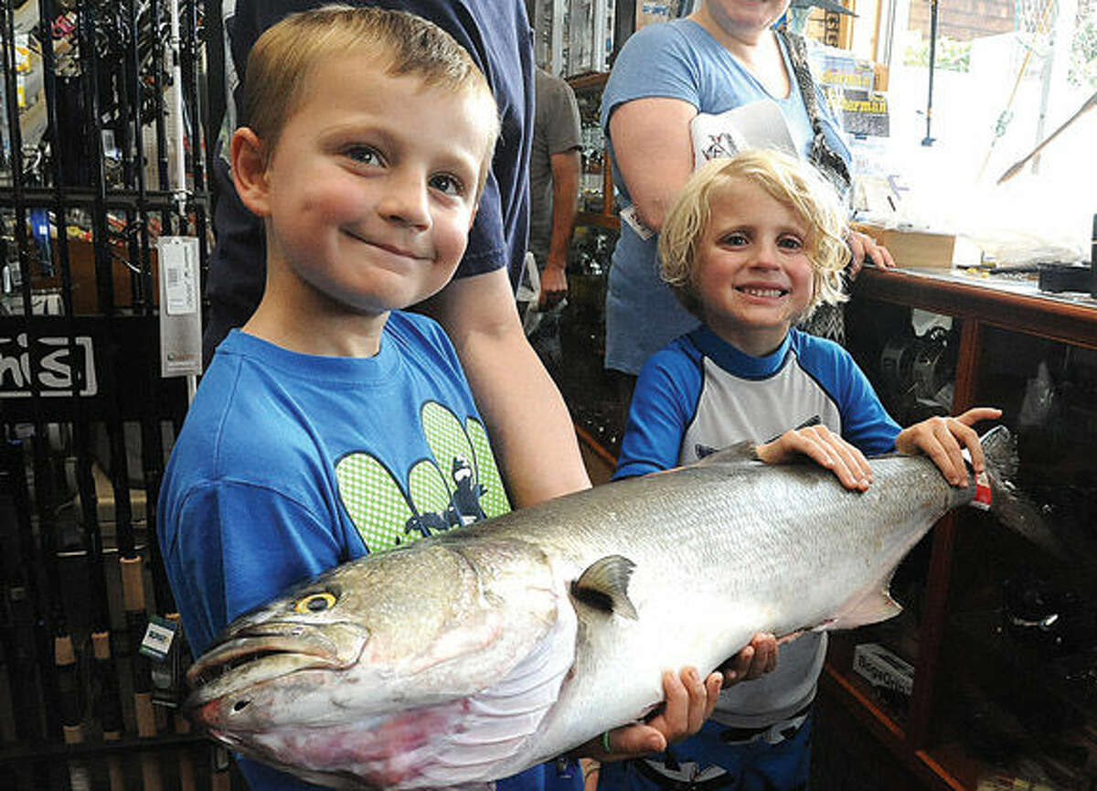 Casey Bumbulis 8, and his little brother Finn 6, with a 13 lbs bluefish Sunday at Fisherma's World in Norwalk. The fish was caught by local fisherman Jason Vlicky and at noon on Sunday it was current port prize catch in the store from the Bluefish contest. Hour photo/Matthew Vinci