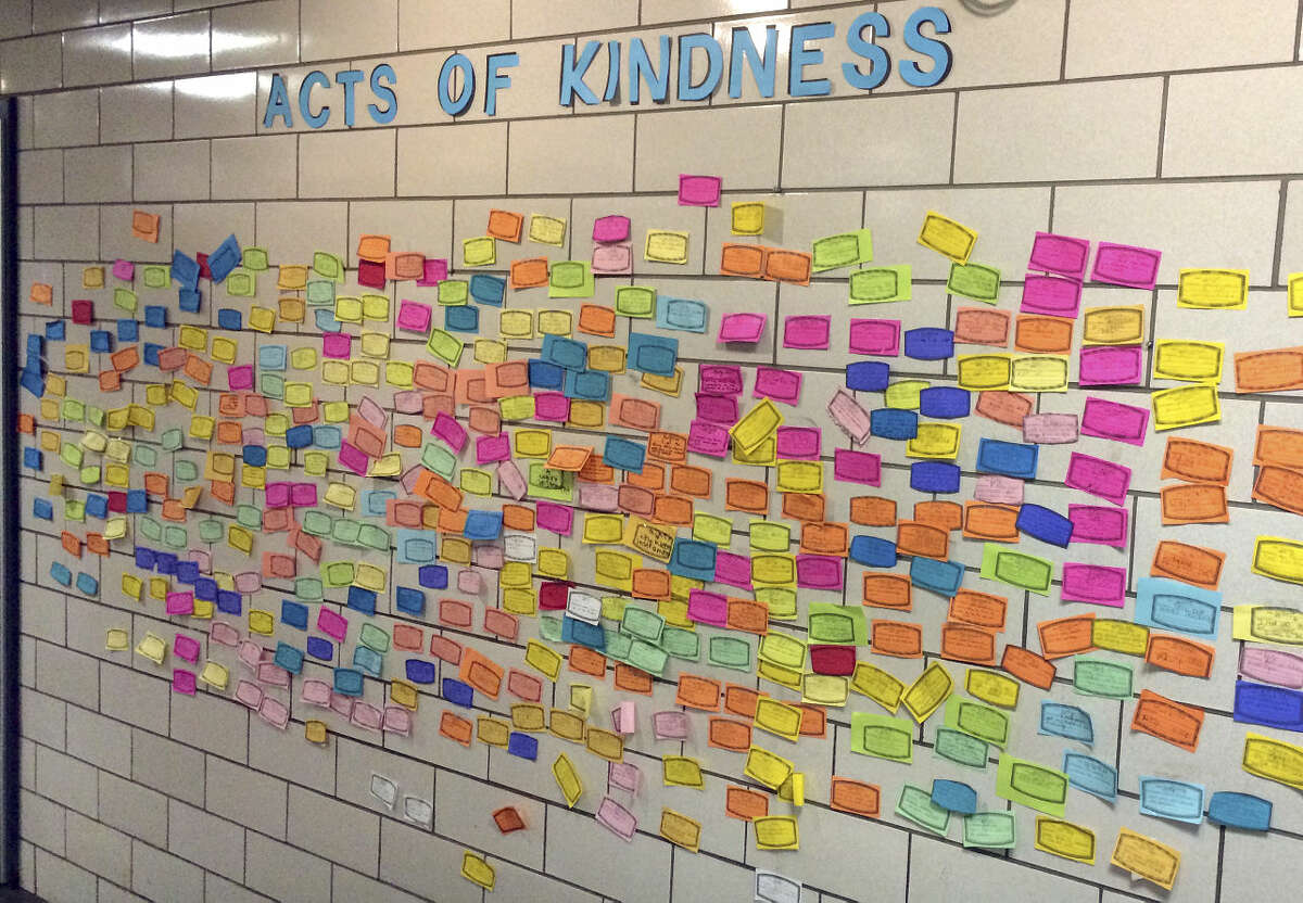 In this Dec. 1, 2015 photo, slips of paper listing acts of kindness adorn the wall of the Pleasant Valley Elementary School in South Windsor, Conn. The school is one of many across the country asking children to perform 26 acts of kindness on the third anniversary of the shooting at the Sandy Hook Elementary school that took 26 lives. The children at Pleasant Valley, many of whom are too young to remember the shooting, are not being told about the origin of the program. (AP Photo/Michael Melia)