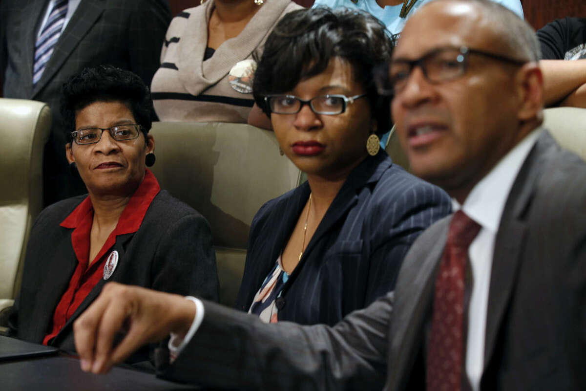 Geneva Reed-Veal, left, and Sharon Cooper, center, the mother and sister of Sandra Bland, listen to attorney Larry Rogers Jr., right, explain concerns about the Texas grand jury's role in the death of Naperville resident Sandra Bland, Monday, Dec. 21, 2015 in Chicago. As a grand jury investigates the case of Sandra Bland, a black woman whose death in a Texas jail shook a raw year in American policing, the state police force at the center of her combative traffic stop is able to shield some complaints under special exemptions and has used what experts say are outdated practices for keeping nearly 4,000 troopers in check. (Phil Velasquez/Chicago Tribune via AP) MANDATORY CREDIT CHICAGO TRIBUNE; CHICAGO SUN-TIMES OUT; DAILY HERALD OUT; NORTHWEST HERALD OUT; THE HERALD-NEWS OUT; DAILY CHRONICLE OUT; THE TIMES OF NORTHWEST INDIANA OUT; TV OUT; MAGS OUT; NO SALES