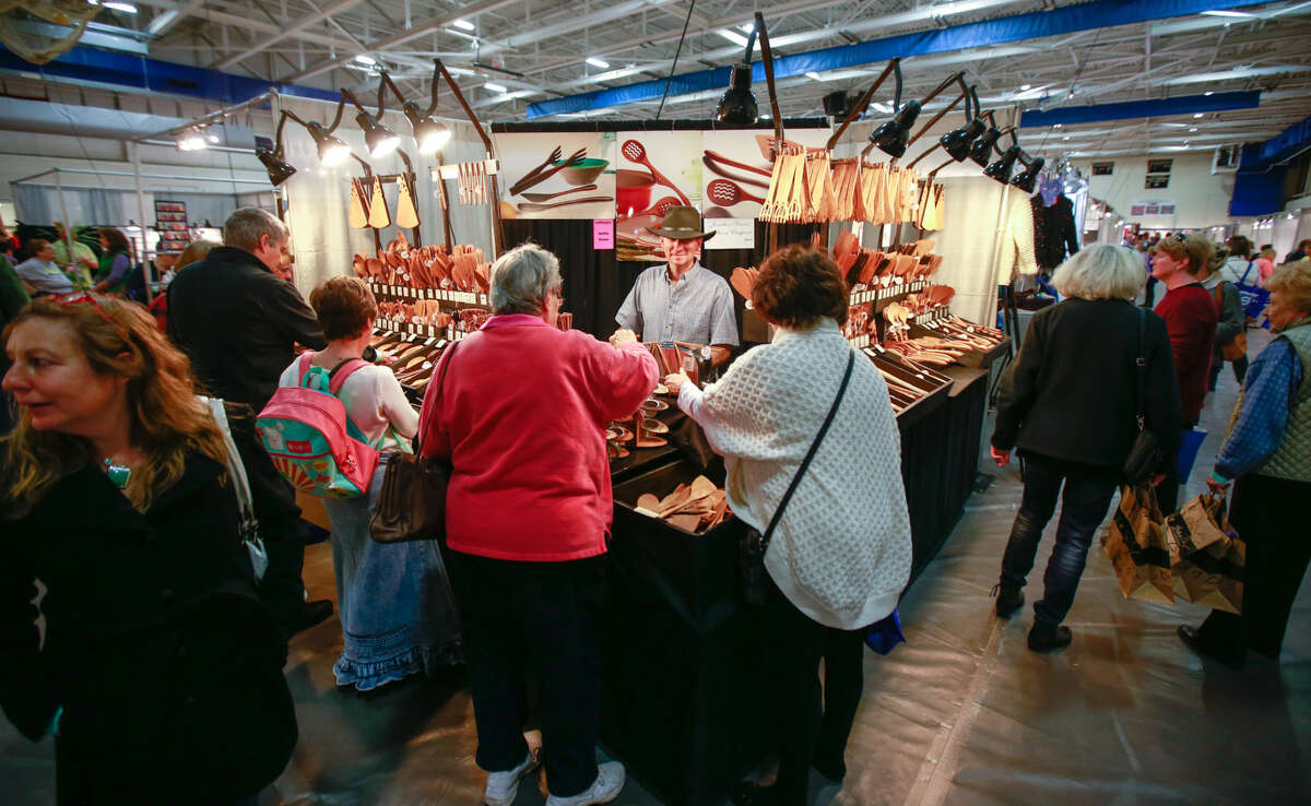 Hour photo/Chris Palermo. Shoppers visit the Jonathan Spoons booth at the CraftWestport pop-up marketplace at Staples High School Saturday.