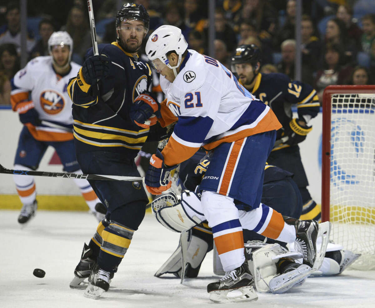 Buffalo Sabres defenseman Josh Gorges (4) battles for the puck with New York Islanders right winger Kyle Okposo (21) during the second period of an NHL hockey game, Thursday Dec. 31, 2015 in Buffalo, N.Y. (AP Photo/Gary Wiepert)