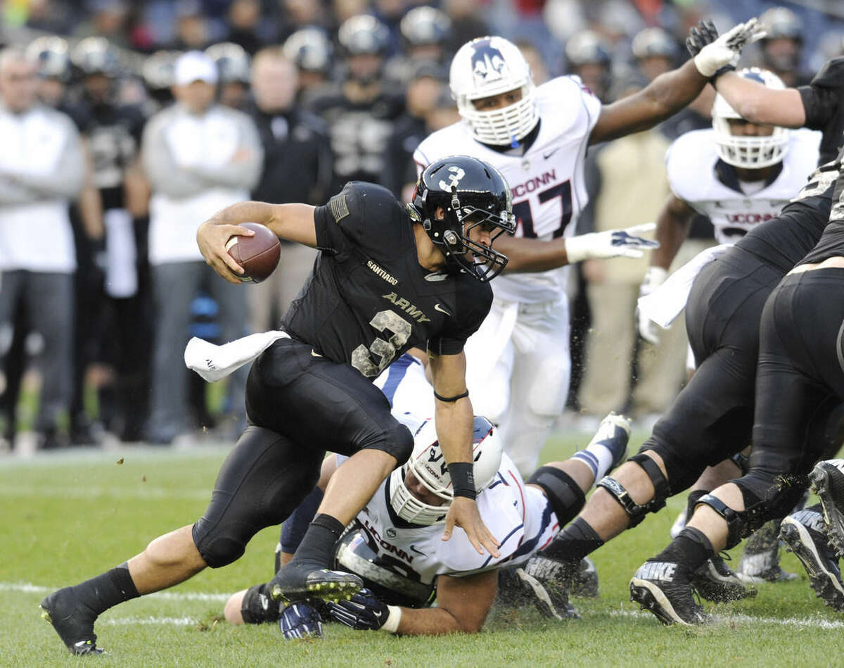 Army quarterback Angel Santiago (3) runs with the ball during the first half of a college football game against Connecticut Saturday, Nov. 8, 2014, at Yankee Stadium in New York. (AP Photo/Bill Kostroun)