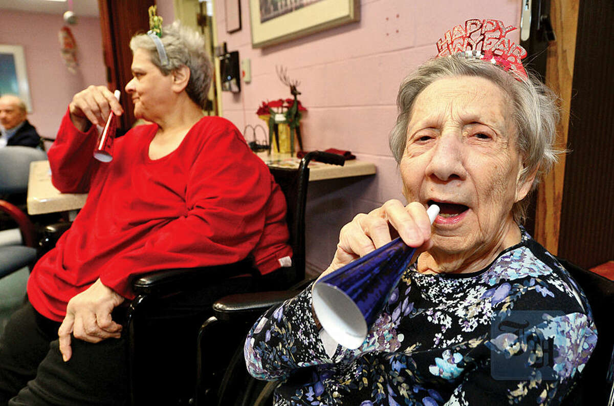 Hour photo / Erik Trautmann Notre Dame Convalescent Home residents including Pauline Fuscoe, right, take part in the facility's New Year's celebration Thursday afternoon.