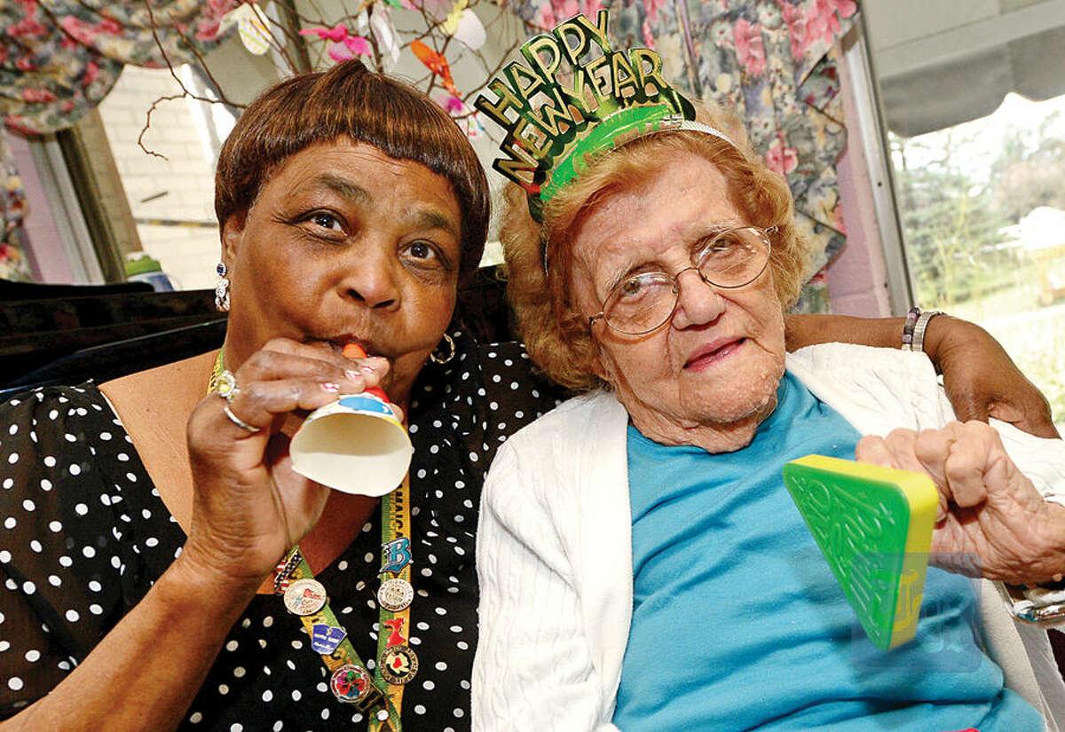 Hour photo / Erik Trautmann Notre Dame Convalescent Home resident Elizabeth Vareha and staffer Kethrine Hinds take part in the facility's New Year's celebration Thursday afternoon.
