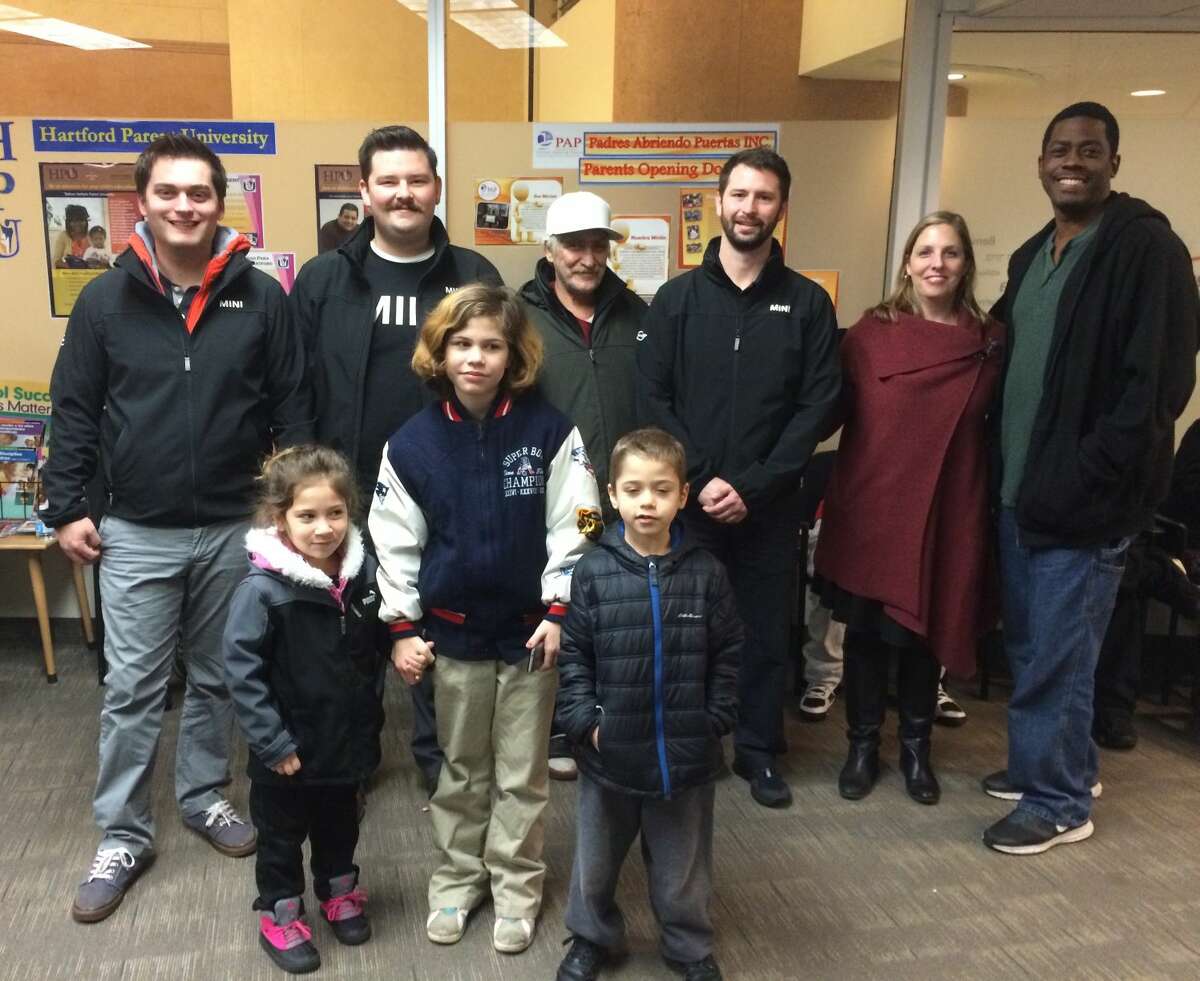 From left, back row: Ben Wetmore, Levi Flaherty, and Sam Herman, from New Country MINI were greeted by Hartford Public School Superintendent Dr. Beth Schiavino-Narvaez and staff when they delivered more than 100 coats collected through New Country’s 2nd Annual “Stuff a MINI to the Max” campaign.  Happy Hartford students model their new coats.