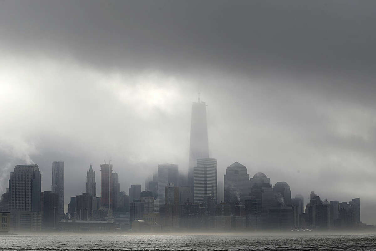 Heavy fog blankets lower Manhattan in New York, including One World Trade Center, center, in this view across the Hudson River from Hoboken, N.J., Wednesday, Nov. 12, 2014. The National Weather Service said the fog reduced visibility to a quarter mile or less. (AP Photo/Julio Cortez)
