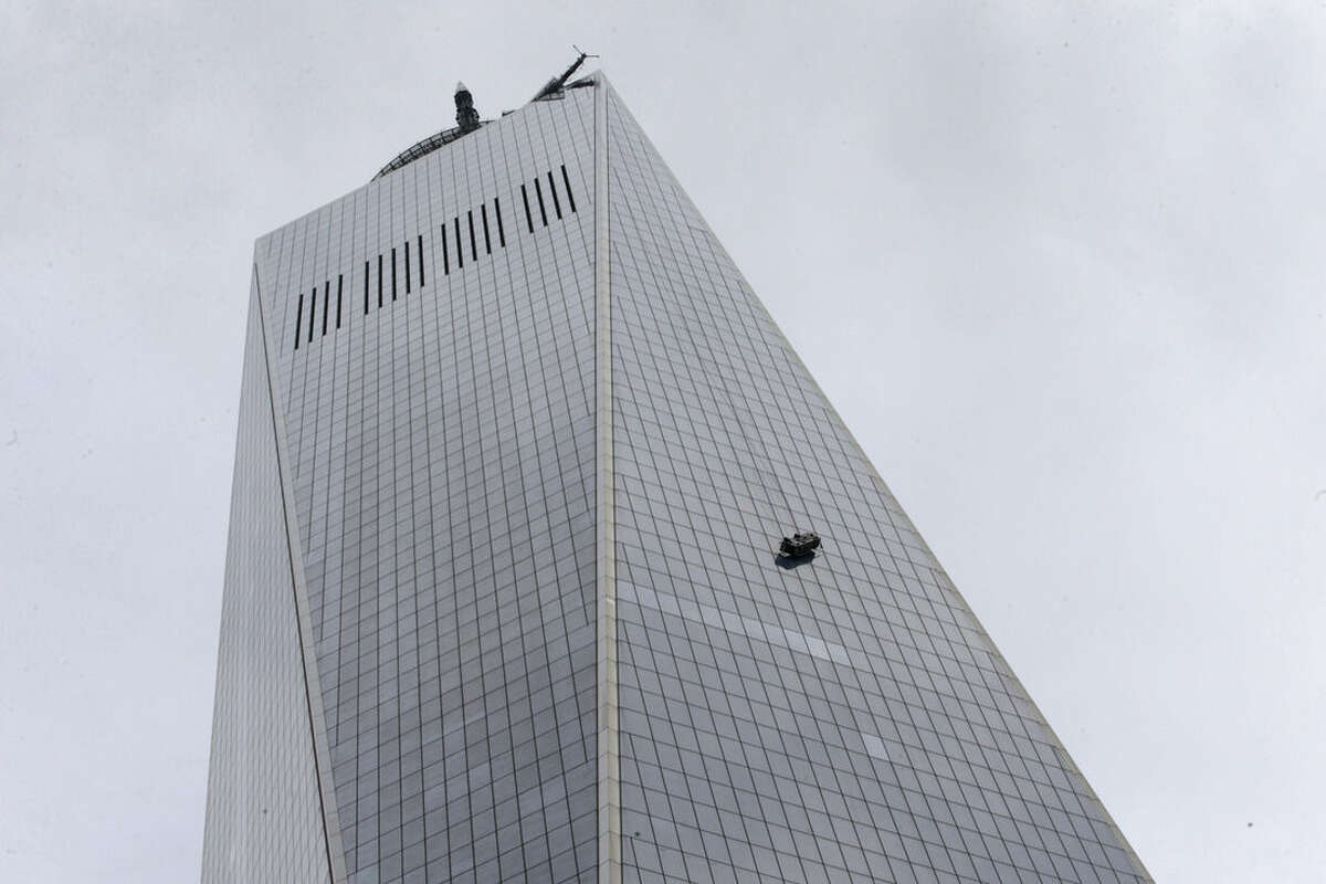 A partially collapsed scaffolding hangs from the 1 World Trade Center in New York, Wednesday, Nov. 12, 2014. New York City firefighters have been called to the nation's tallest skyscraper, where two workers are stuck on scaffolding 69 stories above street level. (AP Photo/Kathy Willens)