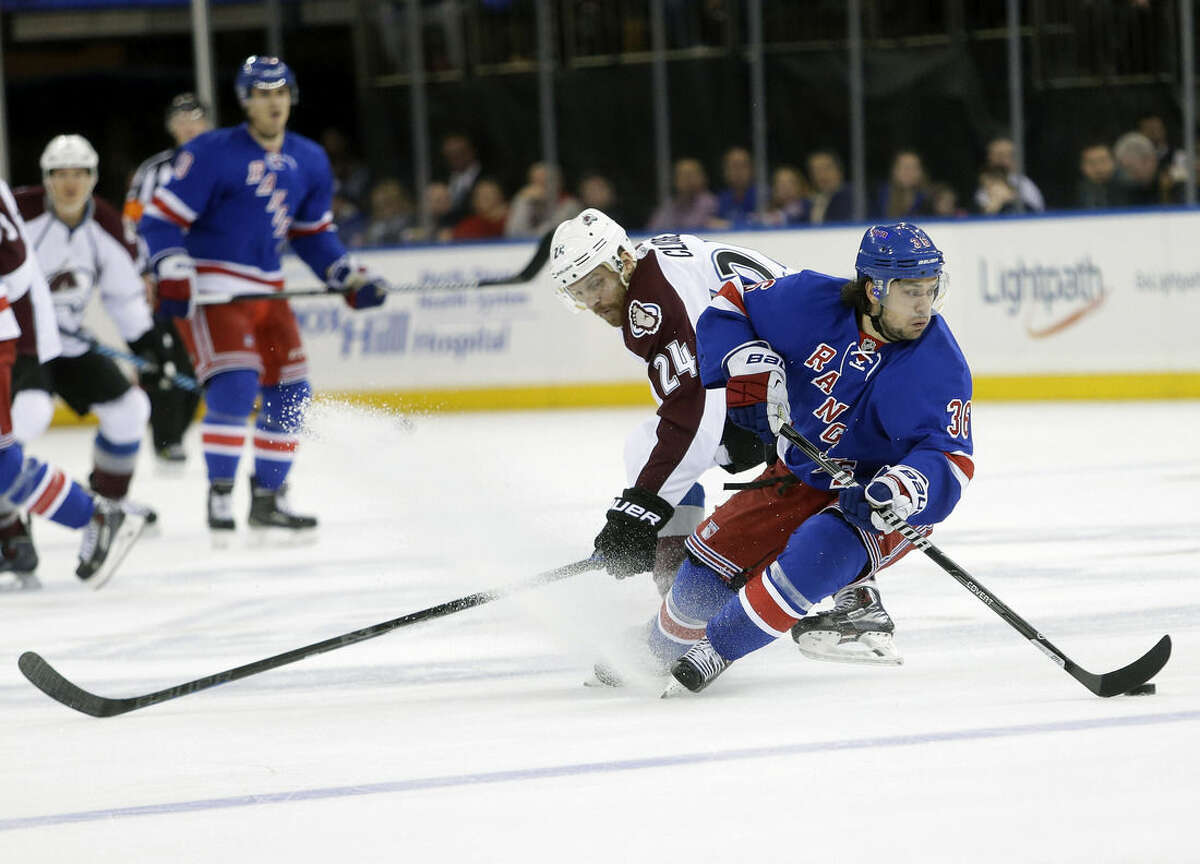 New York Rangers' Mats Zuccarello (36) protects the puck from Colorado Avalanche's Marc-Andre Cliche (24) during the first period of an NHL hockey game Thursday, Nov. 13, 2014, in New York. (AP Photo/Frank Franklin II)