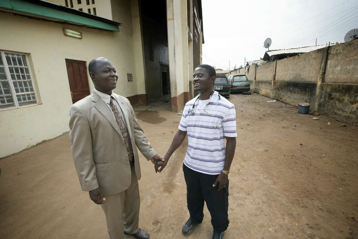In this April 2014 photo provided by the United Methodist News Service, Dr. Martin Salia, right, visits with Bishop John K. Yambasu at the United Methodist Church's Kissy Hospital outside Freetown, Sierra Leone. Salia has tested positive for Ebola and will be flown, on Saturday, Nov. 15, 2014, to the Nebraska Medical Center, in Omaha, Neb., for treatment. (AP Photo/United Methodist News Service, Mike DuBose) MANDATORY CREDIT