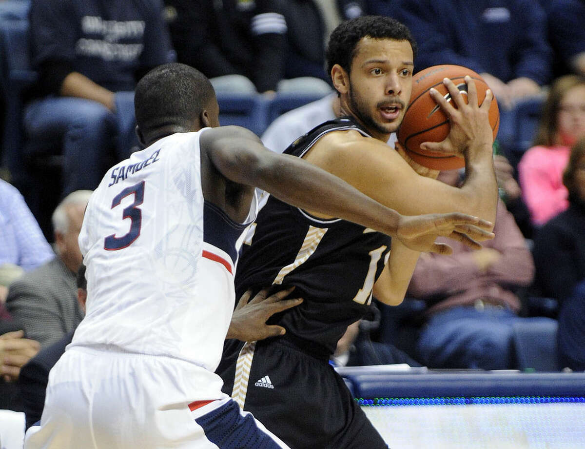Bryant's Dyami Starks (12) is guarded by Connecticut's Terrence Samuel (3) during the first half of an NCAA college basketball game in Storrs, Conn., on Friday, Nov. 14, 2014. (AP Photo/Fred Beckham)