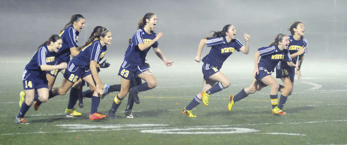 Hour photo/John Nash The Weston girls soccer team raced to celebrate their 2-2 (8-7 PK) win over Suffield in the Class M semifinals. On Saturday, the Trojans get a shot at East Catholic for the state title.