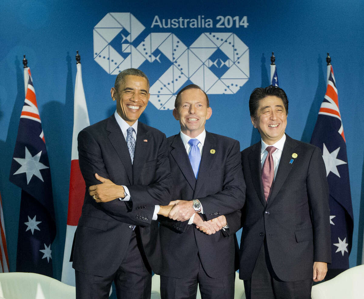 U.S. President Barack Obama, left, Australian Prime Minister Tony Abbott, center, and Japanese Prime Minister Shinzo Abe, right, shake hands at the start of their meeting at the G20 Summit in Brisbane, Australia, Sunday, Nov. 16, 2014. (AP Photo/Pablo Martinez Monsivais)