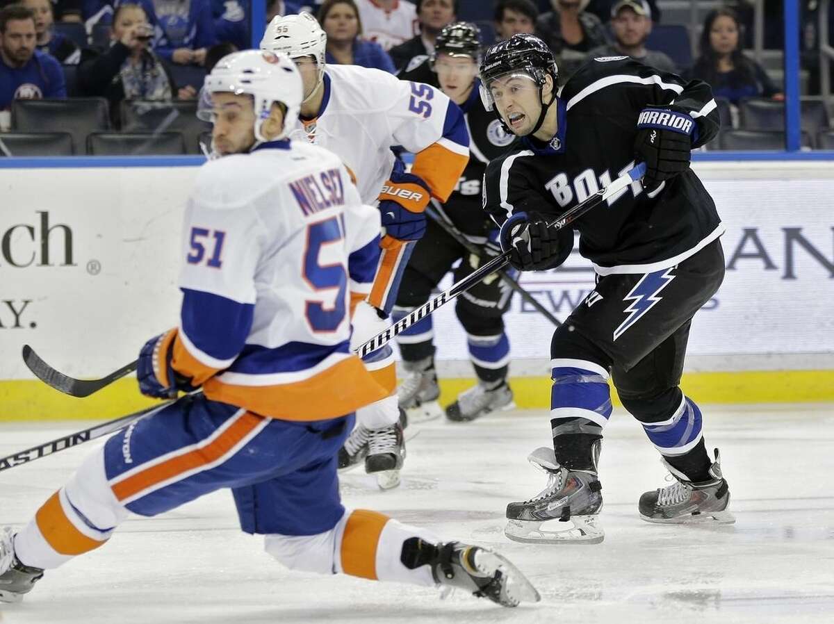 Tampa Bay Lightning center Tyler Johnson (9, right) watches his wrist shot get by New York Islanders center Frans Nielsen (51), of Denmark, and goalie Chad Johnson for a goal during the second period of an NHL hockey game Saturday, Nov. 15, 2014, in Tampa, Fla. (AP Photo/Chris O'Meara)