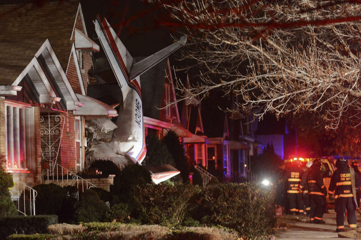 A small twin-engine cargo plane is seen after it crashed into a home on Chicago's southwest side early Tuesday morning, Nov. 18, 2014, shortly after taking off from Midway International Airport. A fire department spokesman says two occupants of the home were unhurt. Authorities did not immediately release information about the pilot's condition. (AP Photo/Sun-Times Media, Brian Jackson)