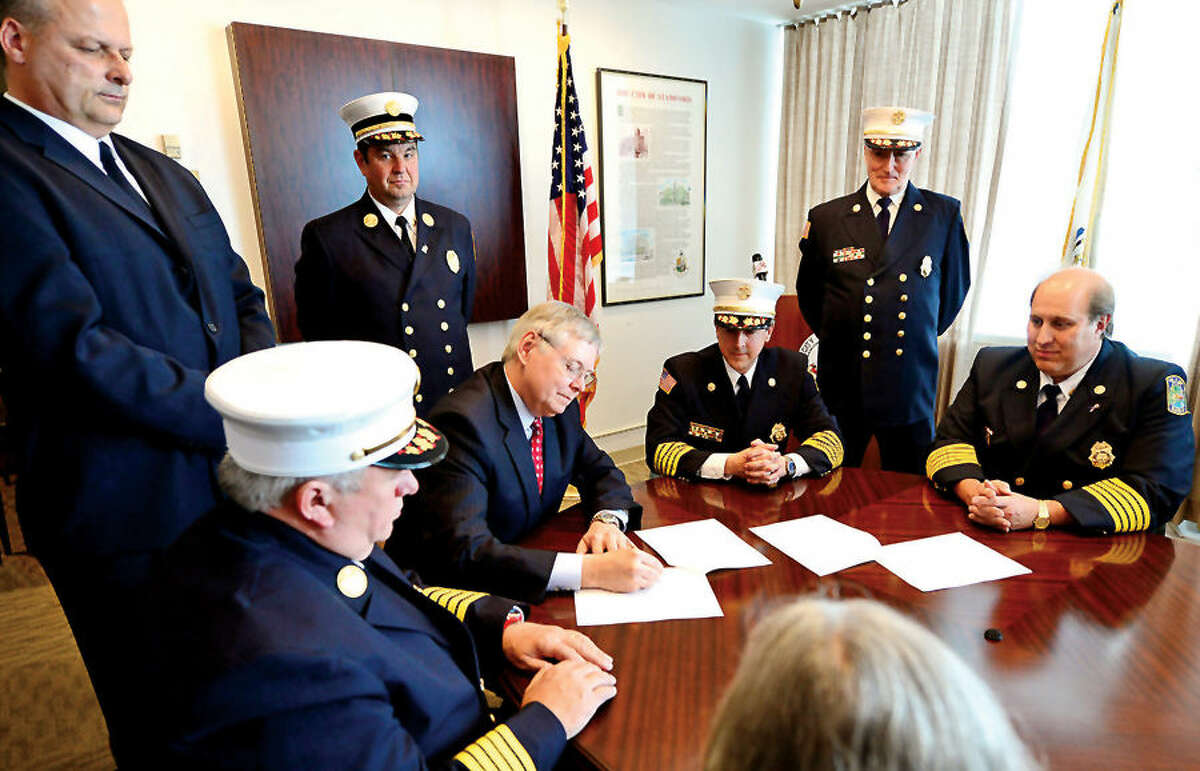 Mayor David Martin, Public Safety Director Ted Jankowski, Fire Chief Peter Brown, Turn Of River (TOR) Chief Frank Jacobellis, TOR Assistant Chief Matt Maounis, and TOR President Nicholas Jossem sign the agreement to consolidate the Stamford and Turn of River Volunteer Fire Departments.
