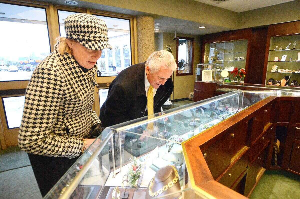 Hour Photo/Alex von Kleydorff Mayor Harry Rilling and Elizabeth Stocker, Director of Economic Development look at a display case of fine jewlery during a visit to David Harvey Jewlers as part of a promotion for Small Businees Saturday