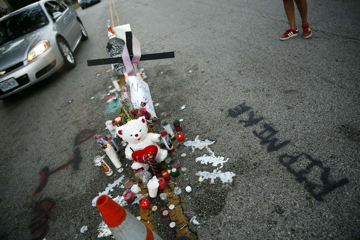 FILE - In this Aug. 11, 2014, file photo, a makeshift memorial sits in the middle of the street where 18-year-old Michael Brown was shot and killed in Ferguson, Mo. After Brown's Aug. 9 shooting death at the hands of a white police officer his legacy continues to evolve. (AP Photo/Jeff Roberson, File)
