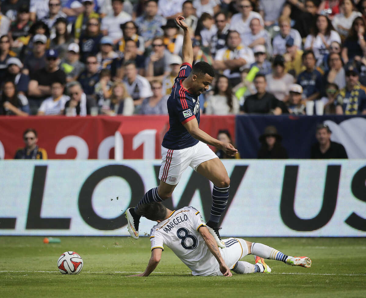 New England Revolution's Charlie Davies, top, jumps to avoid a tackle from Los Angeles Galaxy's Marcelo Sarvas, of Brazil, during the first half of the MLS Cup championship soccer match Sunday, Dec. 7, 2014, in Carson, Calif. (AP Photo/Jae C. Hong)