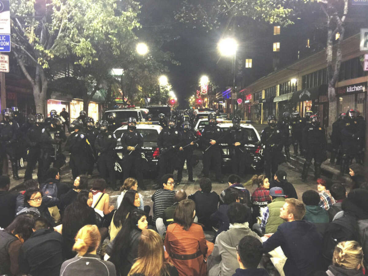 AP photo/Gabriel Reyes This photo provided by Gabriel Reyes shows the protest in Berkeley, Calif., Sunday. Three officers and a technician were hurt and six people arrested in Northern California when a protest over police killings turned violent.