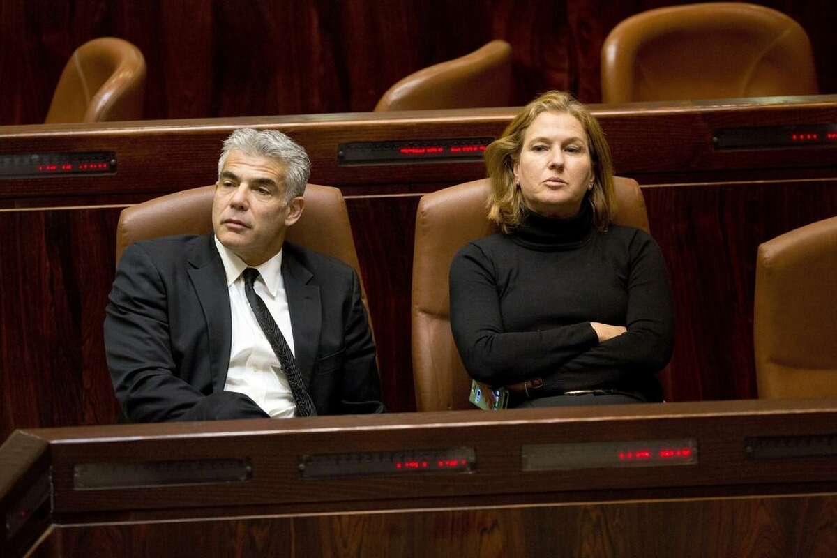 Israeli Finance Minister Yair Lapid, left, and Justice Minister Tzipi Livni sit following a vote at the Knesset, Israel's parliament in Jerusalem, Wednesday, Dec. 3, 2014. Israeli lawmakers voted Wednesday to dissolve the Knesset, a preliminary step that will pave the way for early elections two years ahead of schedule. (AP Photo/Sebastian Scheiner)