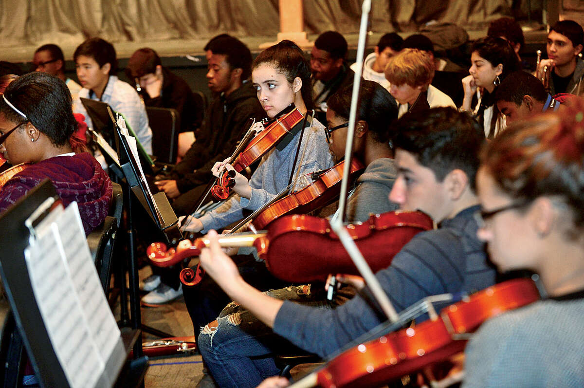 Hour photo / Erik Trautmann Brien McMahon High School choir, orchestra and band including violinist Jackie Aguiar rehearse for its annual Poinsettia winter concert.
