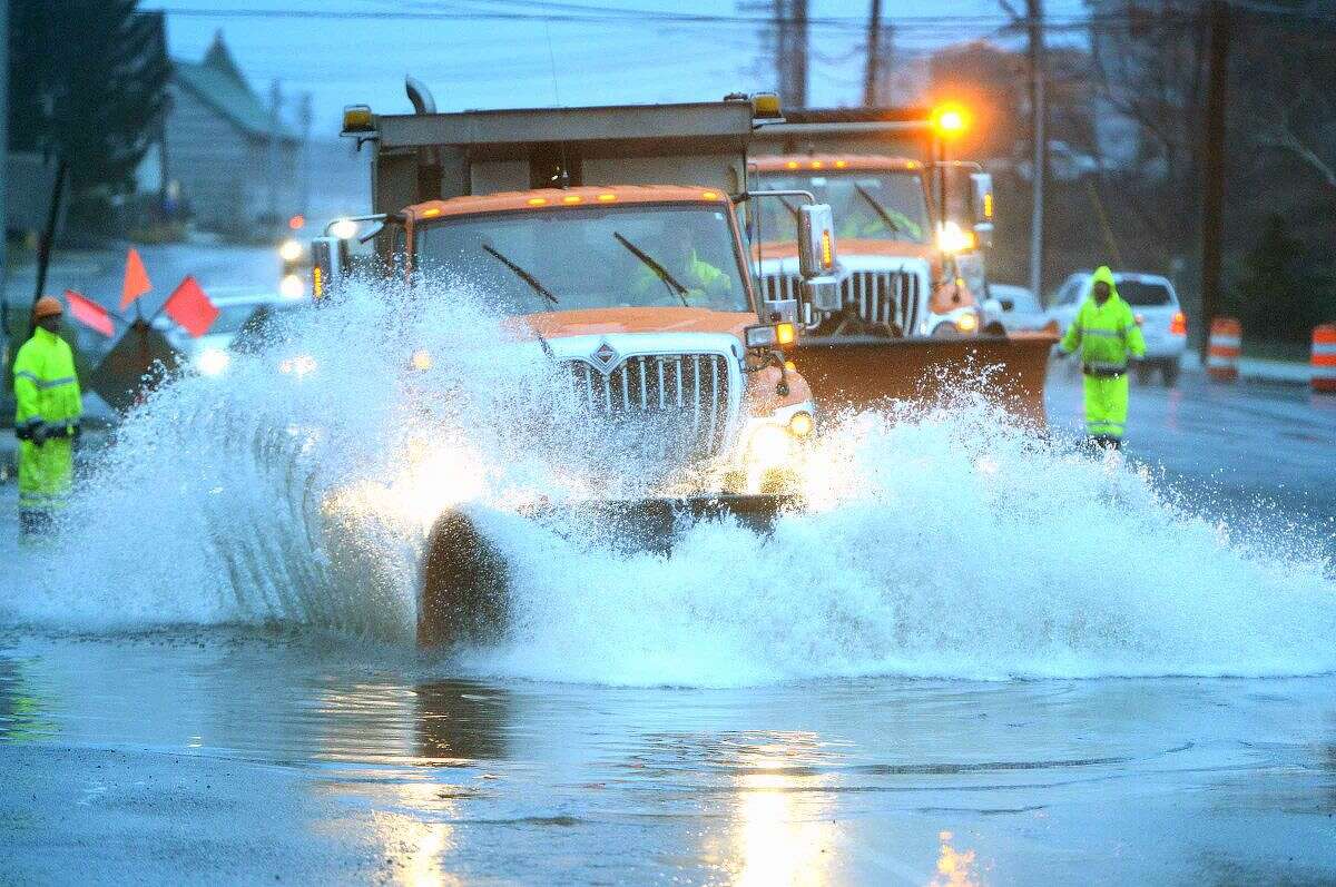 Hour Photo/Alex von Kleydorff State DOT Crews work on clearing a flooded Connecticut Ave at the I95 Soutbound exit ramp using snowplows to clear the more than foot deep water during Tuesday's Nor'easter