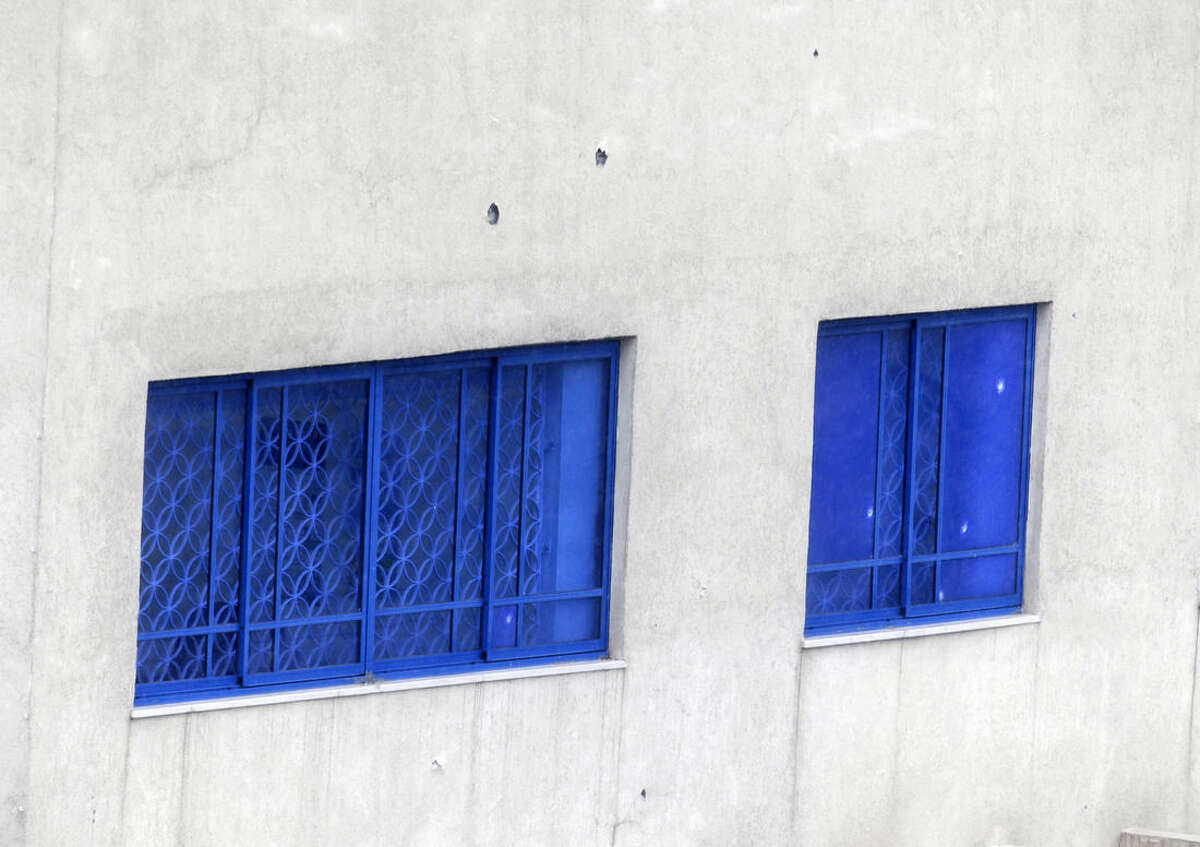 Bullet holes are seen on the wall of Israeli Embassy after a pre-dawn gunfire attack in Athens, Friday, Dec. 12, 2014. Greek authorities are investigating the pre-dawn, drive-by gunfire attack on the Israeli embassy and officials said at least 20 bullet casings were found near the scene of the attack, which occurred long before the building opened for business. (AP Photo/Thanassis Stavrakis)
