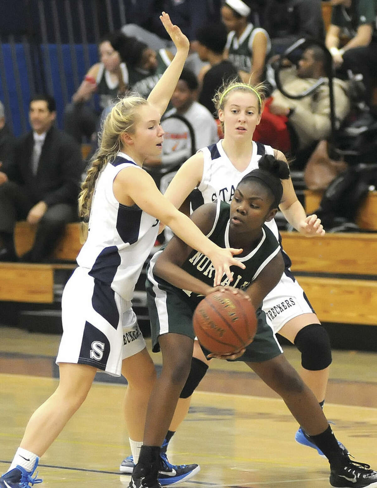 Hour photo/John Nash Norwalk's Asiah Knight, center, is trapped by Staples' Olivia Troy, left, and Tessa Mall, rear, during Wednesday's season-opening FCIAC girls basketball game in Westport. Staples won, 43-38.