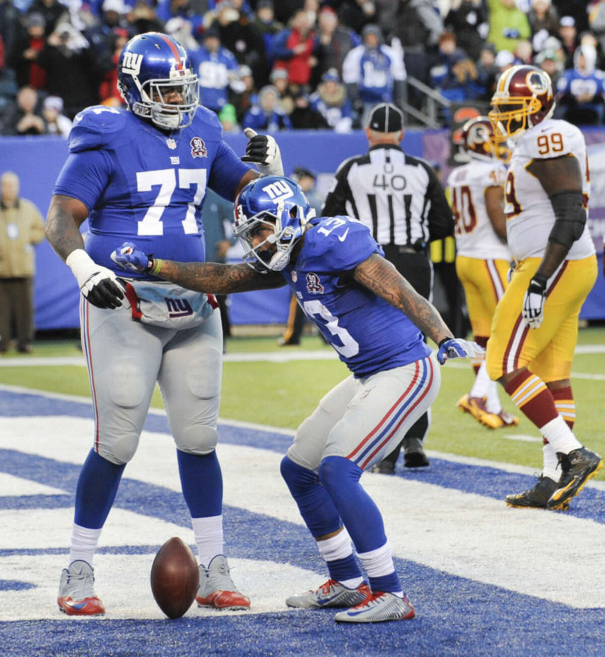 New York Giants wide receiver Odell Beckham Jr. (13) reacts with guard John Jerry (77) after scoring a touchdown against the Washington Redskins during the fourth quarter of an NFL football game, Sunday, Dec. 14, 2014, in East Rutherford, N.J. (AP Photo/Bill Kostroun)