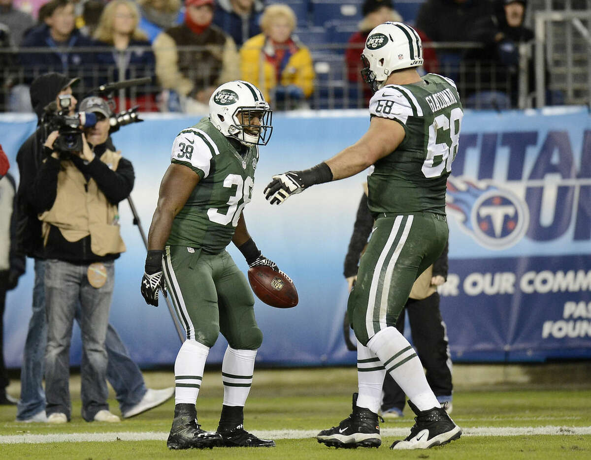 New York Jets fullback John Conner (38) celebrates with tackle Breno Giacomini (68) after Conner scored a touchdown against the Tennessee Titans on a 9-yard pass in the second half of an NFL football game Sunday, Dec. 14, 2014, in Nashville, Tenn. (AP Photo/Mark Zaleski)