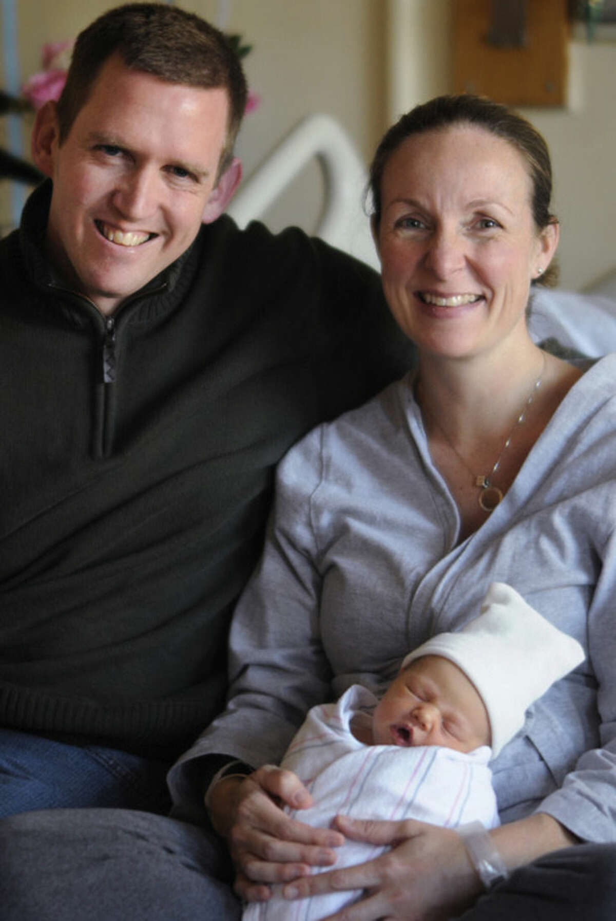 In a Sunday, Dec. 14, 2014 photo, Matthew and Jennie Keane pose with newborn daughter, Claire Elizabeth, born who was born at 10:11 a.m. on Saturday, making her birth time and date 10:11, 12-13-14. The Keanes, of Uxbridge, Mass.,hadn't even thought of the possible numerical feat until a nurse at UMass Memorial Medical Center in Worcester mentioned the combination. (AP Photo/Worcester Telegram & Gazette, Christine Peterson)