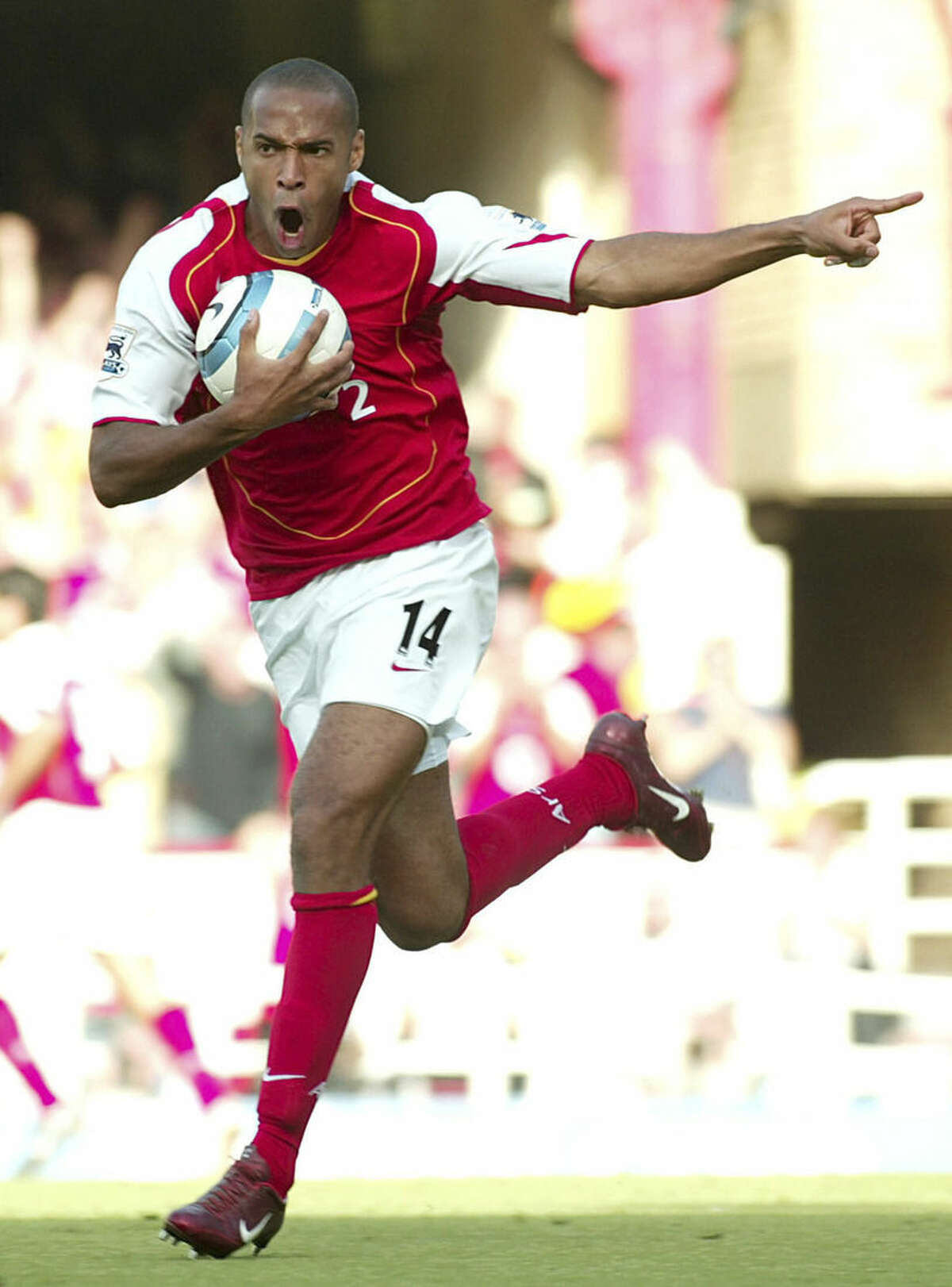 FILE - In this Sunday, Aug. 22, 2004 file photo Arsenal's Thierry Henry celebrates after team mate Dennis Bergkamp scored Arsenal's third goal during the Premiership game between Arsenal and Middlesbrough at Highbury, London. Thierry Henry has announced his retirement following a 20-year career. The 37-year-old Henry, a member of the France teams that won the 1998 World Cup and 2000 European Championship, will take up a media role as a consultant for Sky Sports channel. (AP Photo/John D McHugh, File)