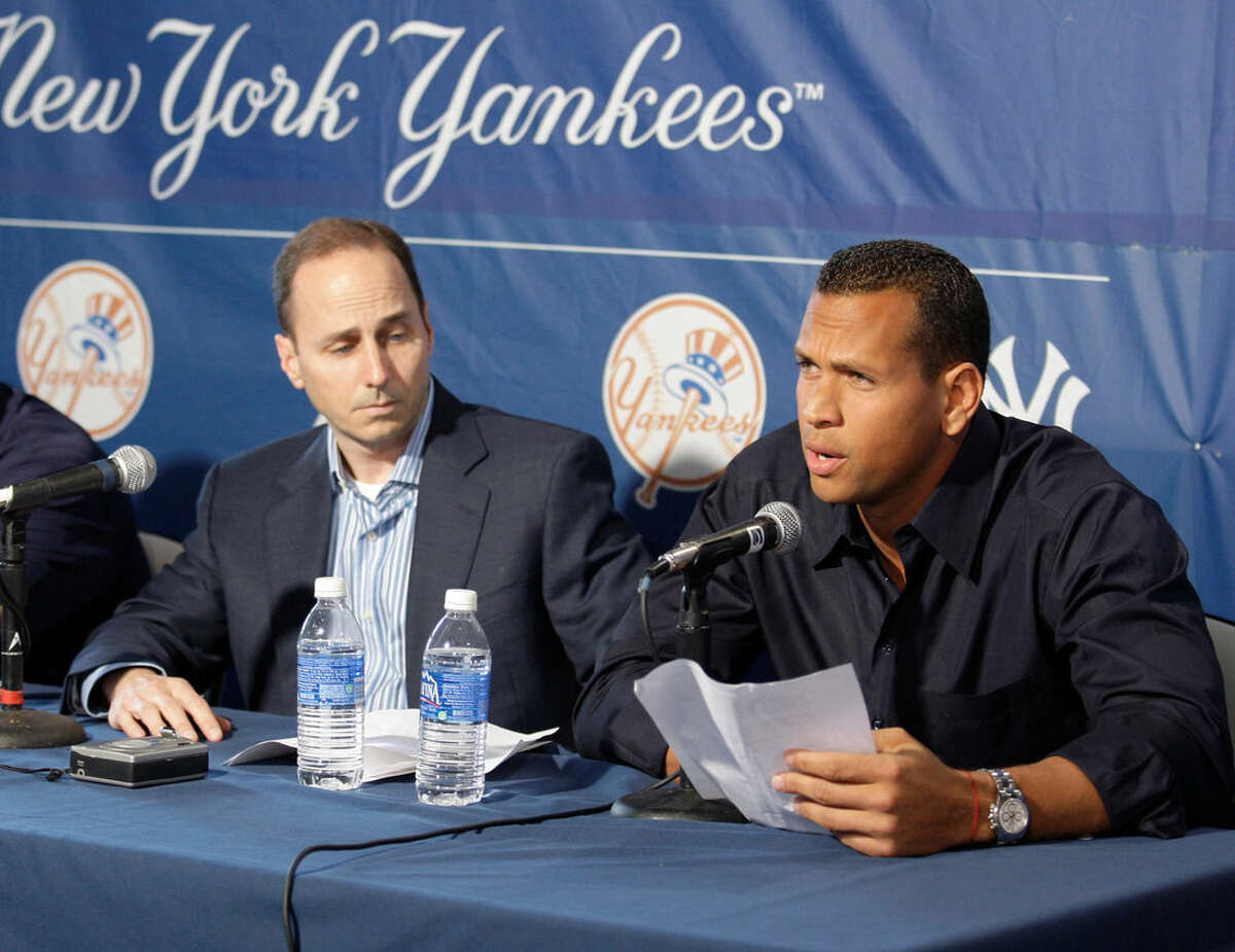 FILE - In this Feb. 17, 2009, file photo, New York Yankees' Alex Rodriguez reads a statement to the media alongside Yankees general manager Brian Cashman after arriving at George Steinbrenner Field in Tampa, Fla. Alex Rodriguez isn't yet at the weight the New York Yankees want him to be at when he reports to spring training in two months. Yankees general manager Brian Cashman said Matthew Krause, the team's strength and conditioning coordinator, visited A-Rod on Wednesday, Dec. 10, 2014, in Miami. (AP Photo/Gene J. Puskar, File)