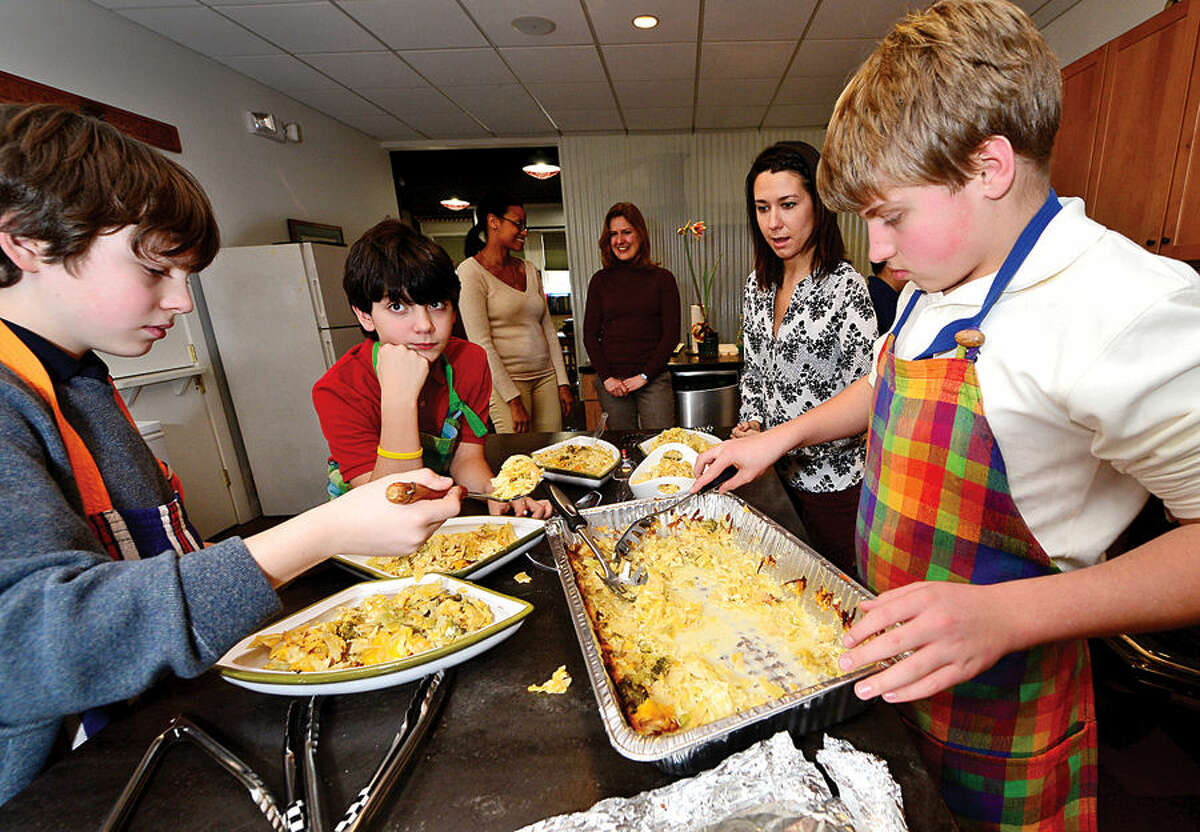 Hour photo / Erik Trautmann The Montessori School’s middle school students Dylan Rosenbloom, BenO'Brien and Shane Cooper, prepare the school's annual holiday lunch Thursday to serve to residents of the Norwalk Shelter.