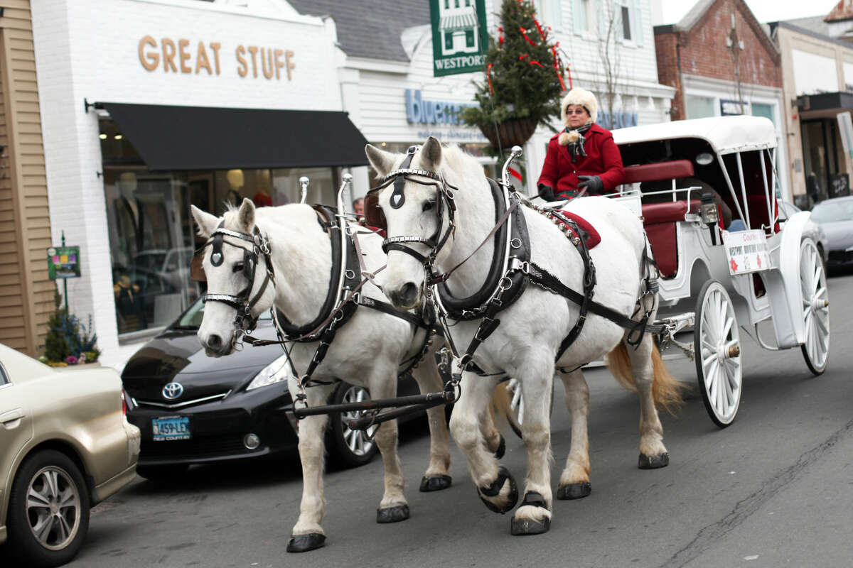 Hour photo/Chris Palermo. Beth Podnajecki of Loon Meadow Farm of Norfolk, CT gives horse and buggy rides on Main Street in Westport Sunday morning. The Westport Downtown Merchants Association celebrated the season with downtown holiday entertainment for the community.