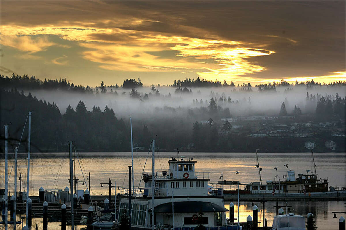 Low clouds hover in the trees in Port Orchard as photographed from the Bremerton Harborside Marina in Bremerton, Wash., Monday, Dec. 22, 2014. (AP Photo/Kitsap Sun, Larry Steagall)