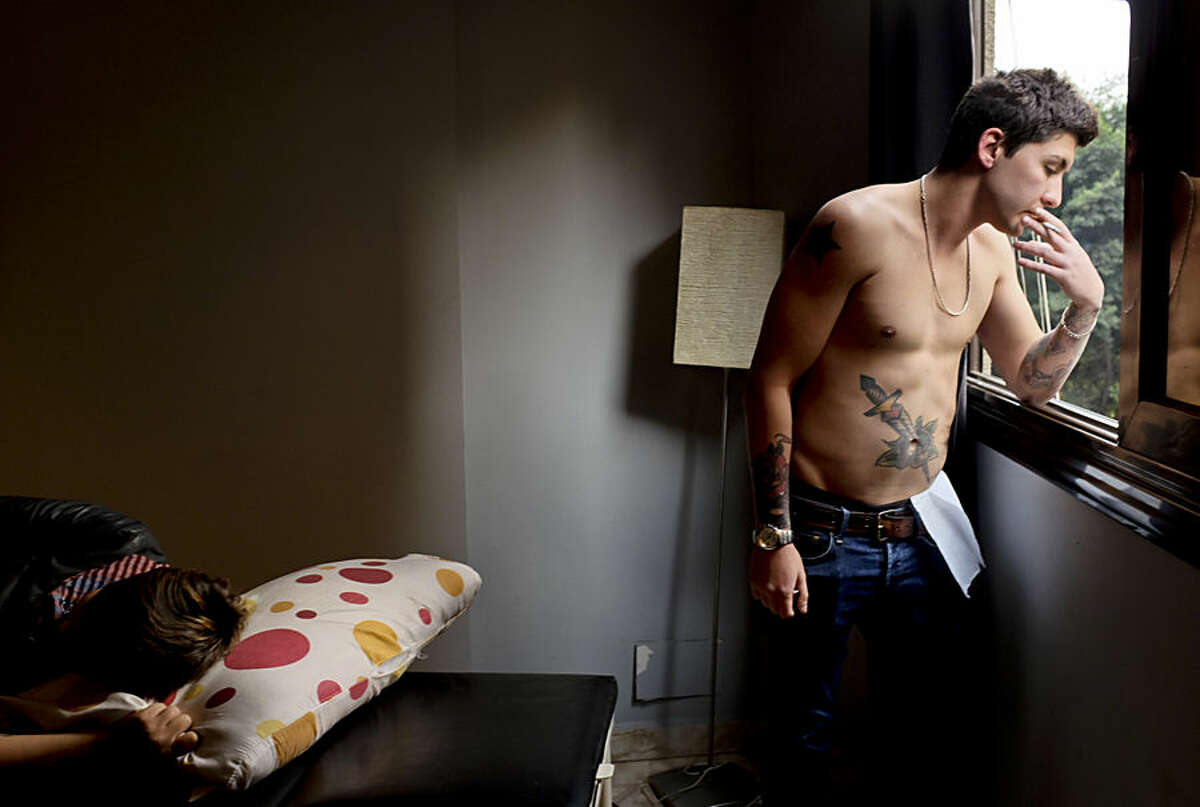 In this Thursday, Dec. 18, 2014 photo, Egyptian 25-year-old Tamer el-Strafy takes a cigarette break at 'Nowhere Land Tattoo Studio,' in Cairo, Egypt. In a country where tattoos are considered taboo for most of the population, organizers in Egypt have held a convention to challenge stereotypes and show-off the ink designs as an art form. (AP Photo/Razan Alzayani)