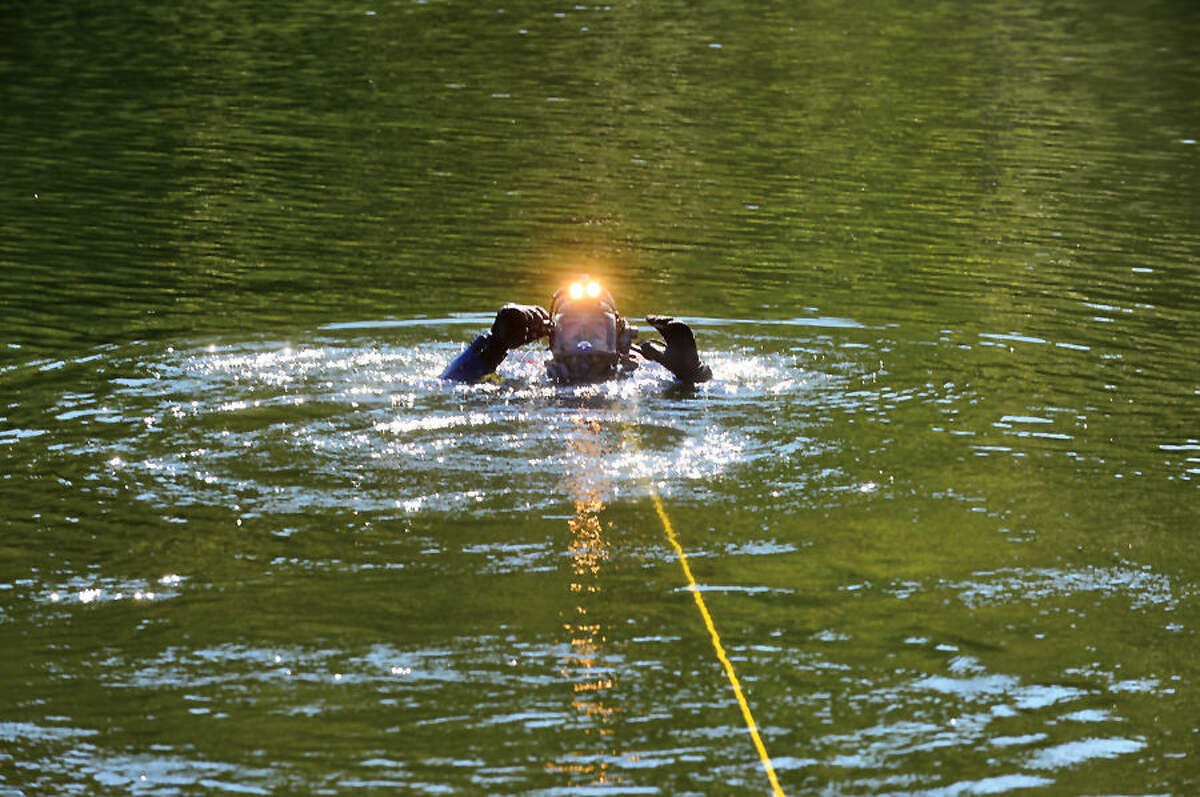 Hour photo / Erik Trautmann Wilton fierfighter Bill Wilson and the Wilton and Westport Police and Fire Departments conduct water rescue training with their dive units Thursday morning in Wilton.