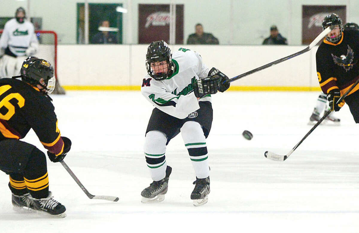 Hour photo / Erik Trautmann #2 of the Norwalk/McMahon high school co-op hockey team, Derek Lue, takes a shot against the Eastern Connecticut Eagles at the SoNo Ice House Saturday.