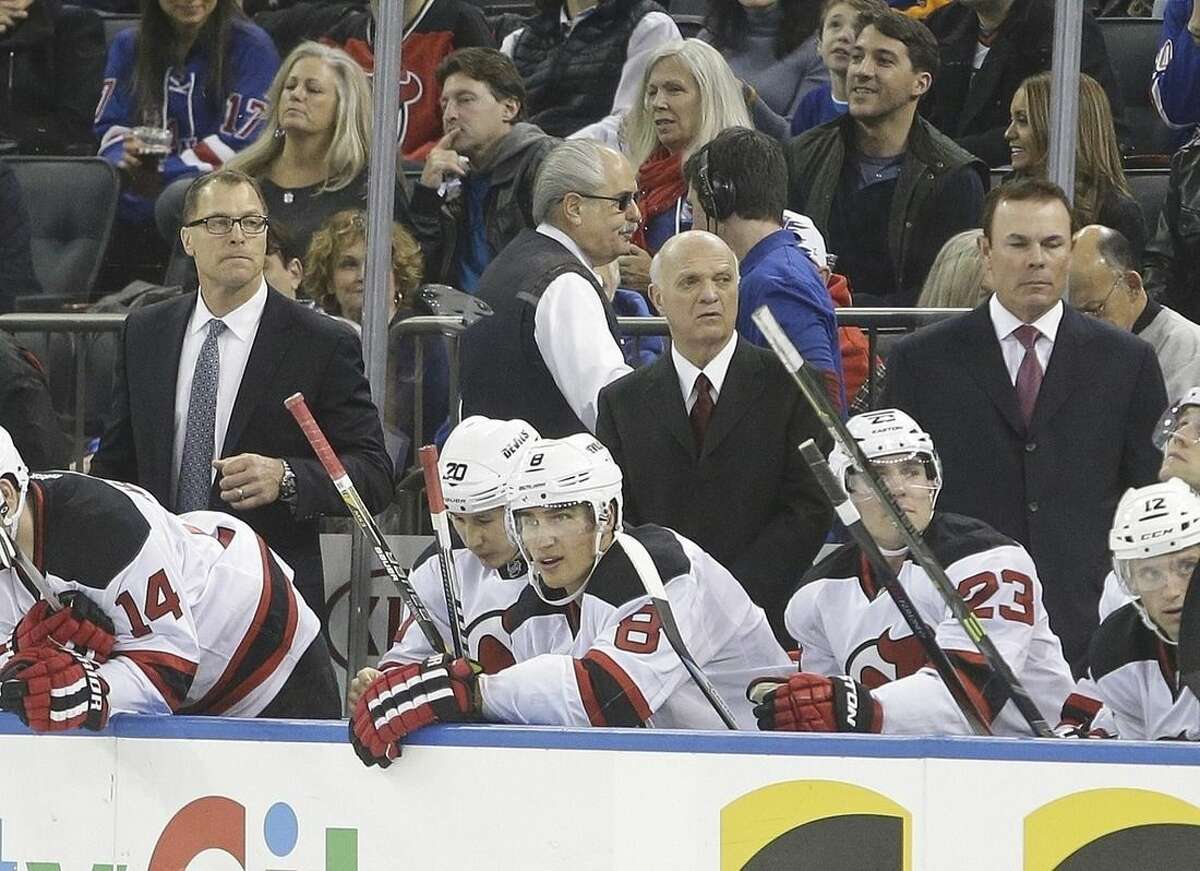 New Jersey Devils General Manager Lou Lamoriello, center, Adam Oates, right, and Scott Stevens, left, watch their team play during the first period of an NHL hockey game against the New York Rangers, Saturday, Dec. 27, 2014, in New York. (AP Photo/Frank Franklin II)