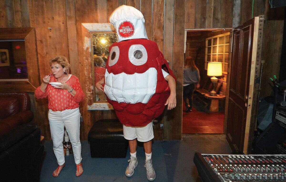 Hour Photo/Alex von Kleydorff Debbie Santos finds a quite spot to sample, next to the Local Meatball Co. Mascot during The Meatball Challenge of Fairfield County at The Factory Underground in Norwalk