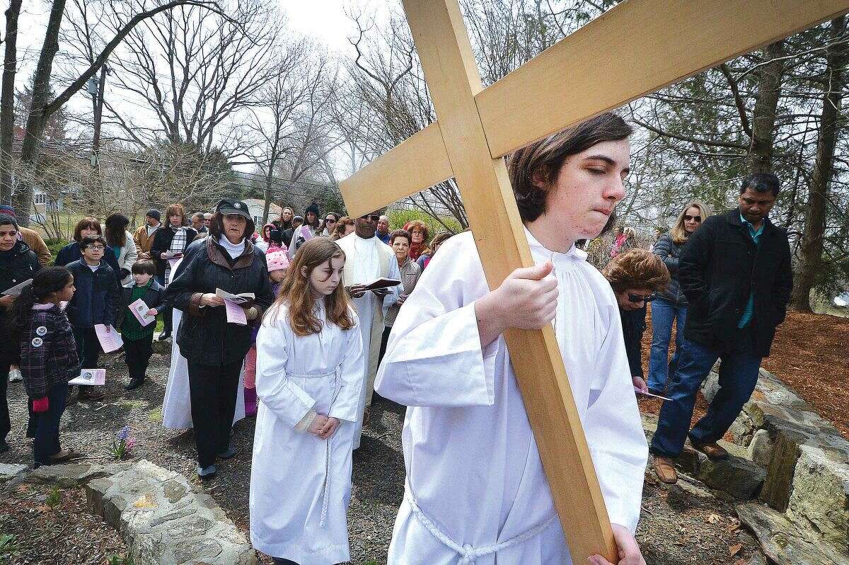 Hour Photo/Alex von Kleydorff. Altar Server Jack Carlan carries the cross during the outdoor Stations of The Cross at St Matthew Church on Good Friday